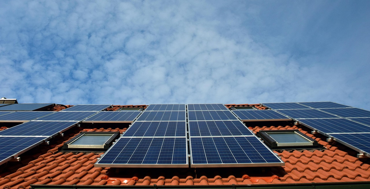 Glückliche Familie vor ihrem Einfamilienhaus mit Solaranlage in der Schweiz